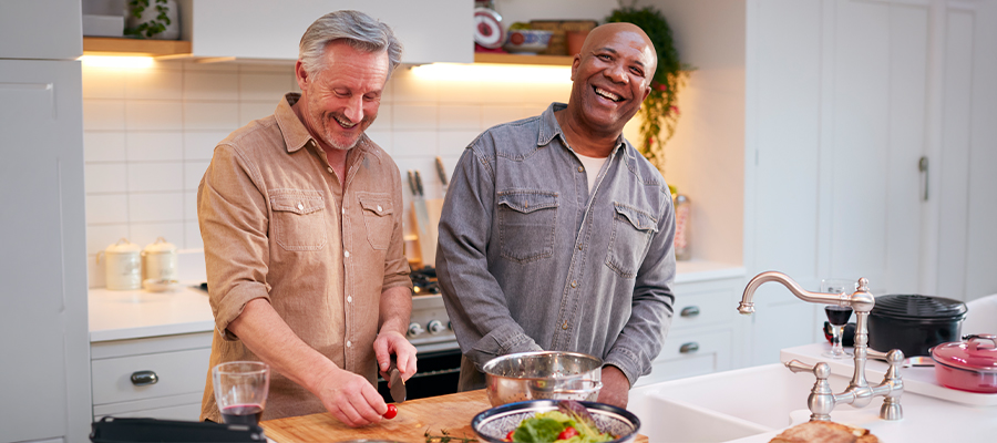 two men cooking and laughing in the kitchen